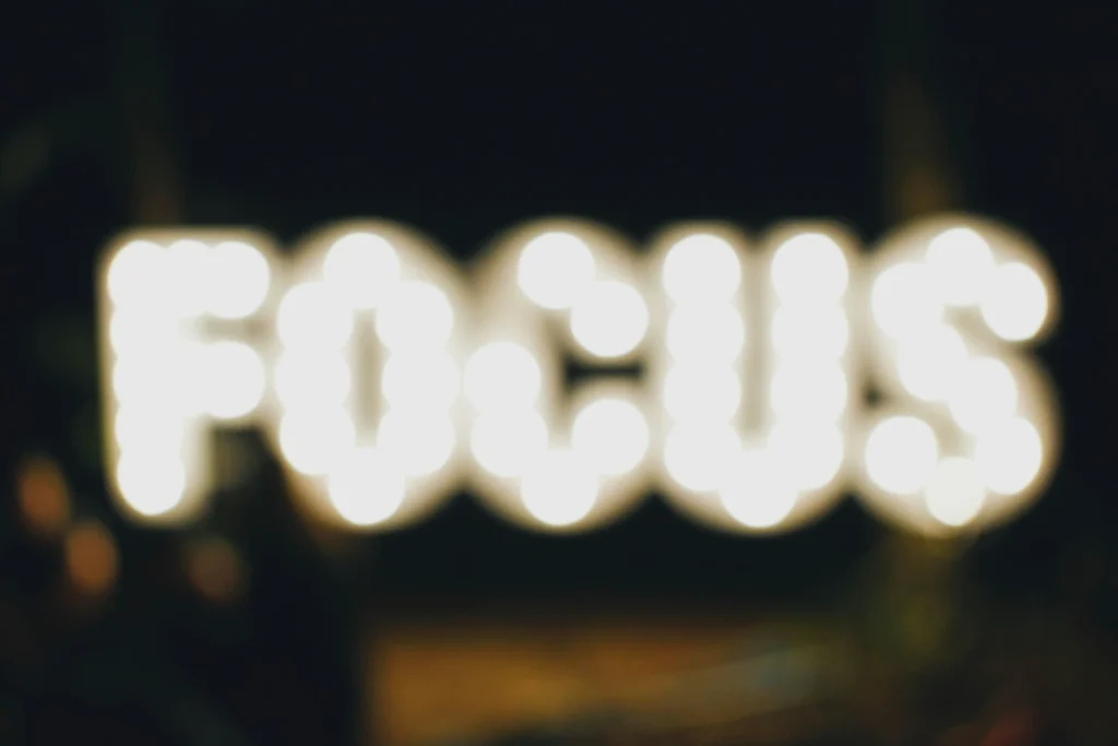 The word "focus" is written in lights and out of focus