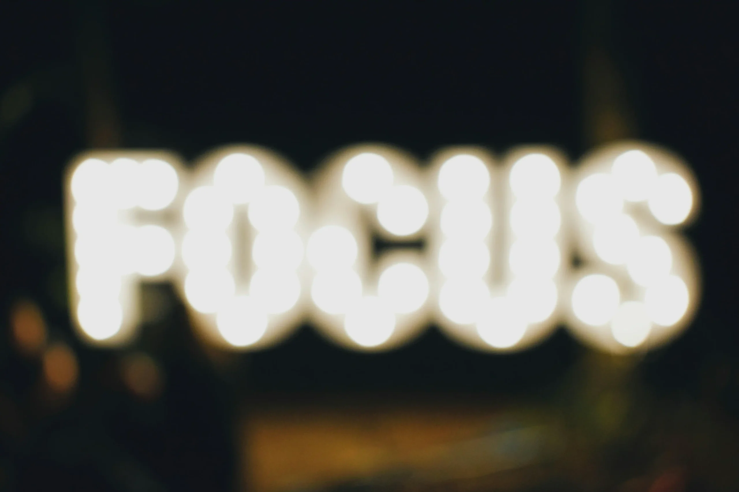 The word "focus" is written in lights and out of focus