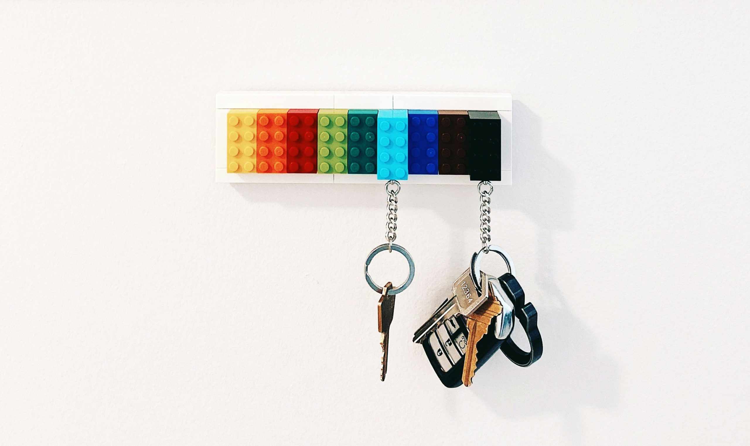Household keys hanging on hooks that look like Lego blocks.