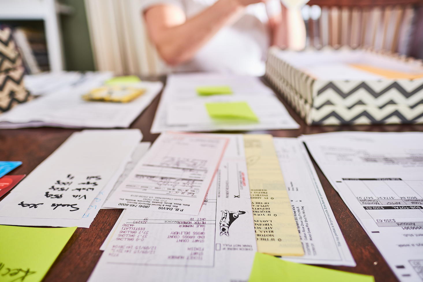 Woman at a table sorting and organizing paperwork.